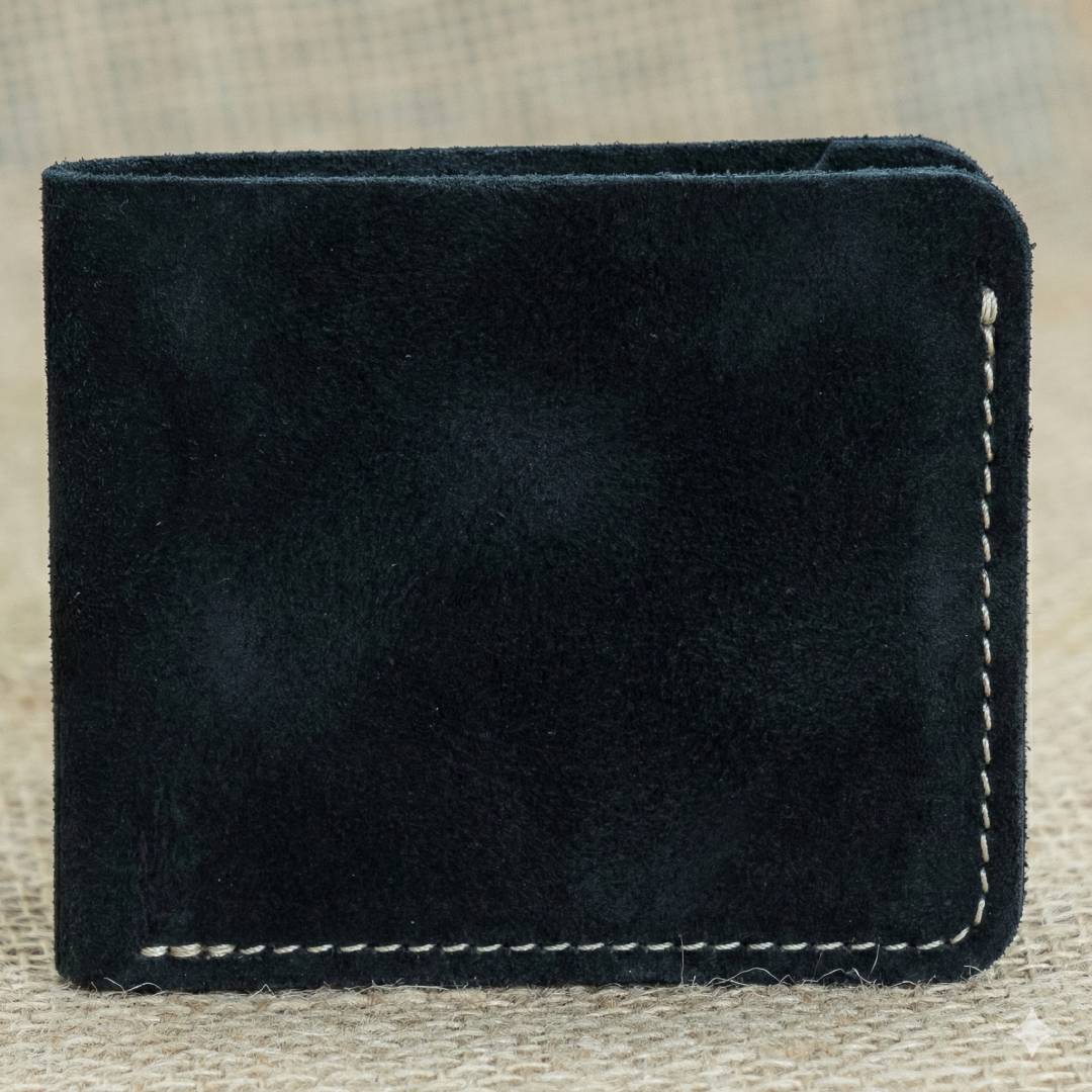 Black leather wallet with white stitching on a textured beige background