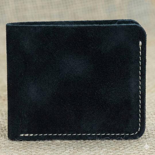 Black leather wallet with white stitching on a textured beige background