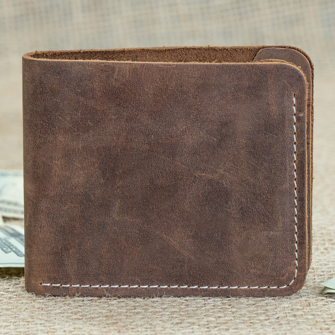 Brown leather wallet on a textured surface