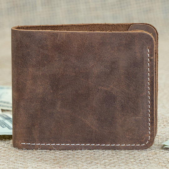 Brown leather wallet on a textured surface