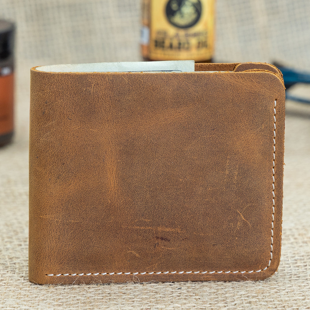 Brown leather wallet on a textured surface with a blurred background