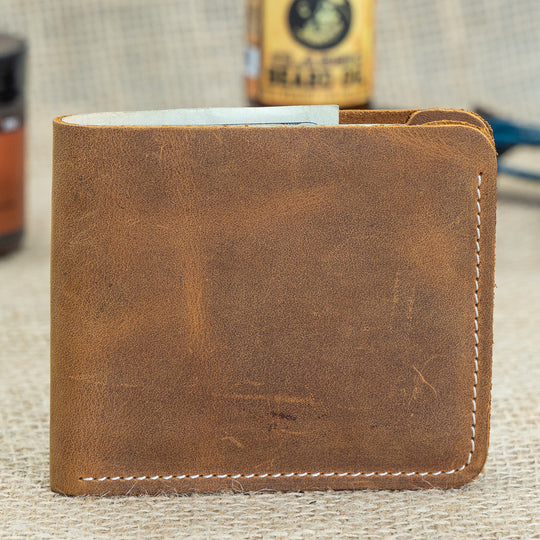 Brown leather wallet on a textured surface with a blurred background