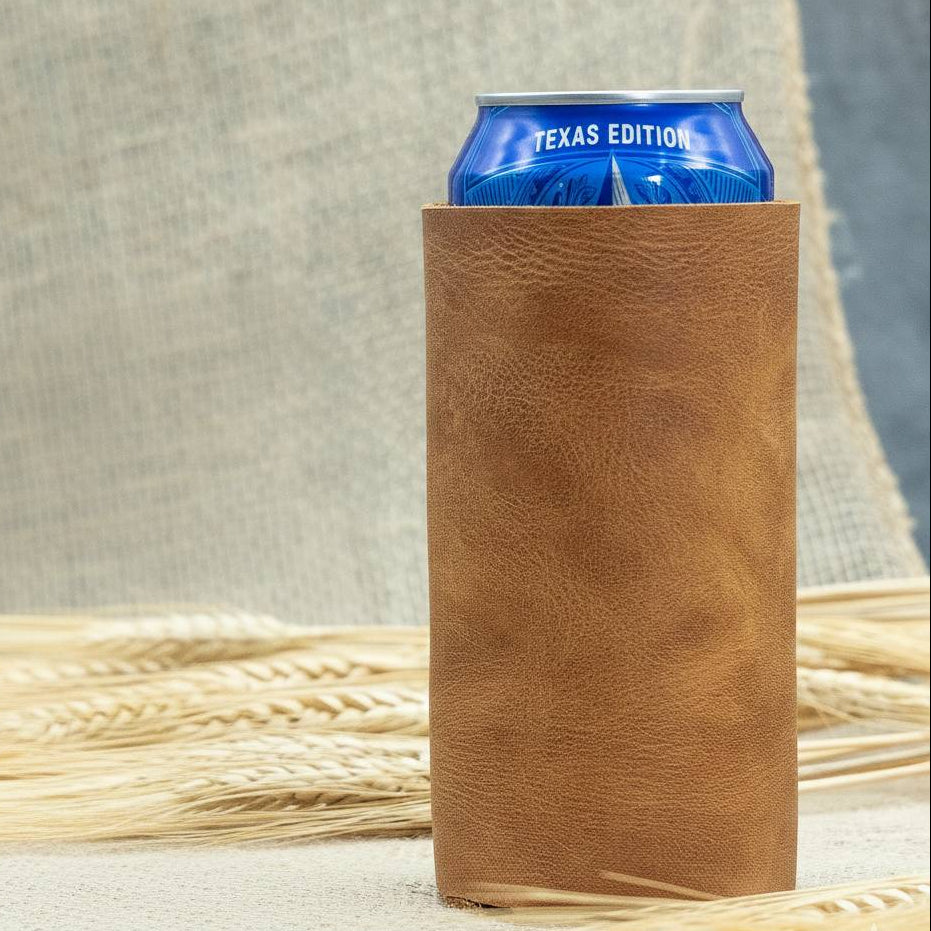 Brown leather can holder with a blue 'Texas Edition' can inside, placed on a textured surface with straw.